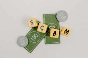 Illustration of shield protecting money from scammer hands.