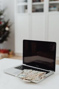 Man at laptop looking satisfied, earning money from side hustle.