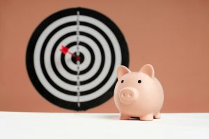 Illustration of a person reaching for a piggy bank with a broken chain.